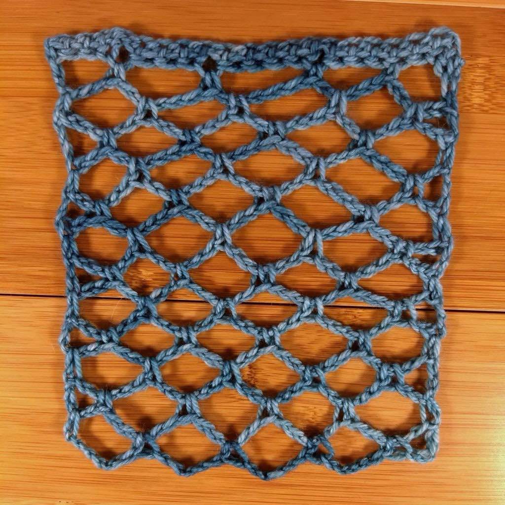 Anzula lace swatch shown laid flat and blocked on a wooden surface