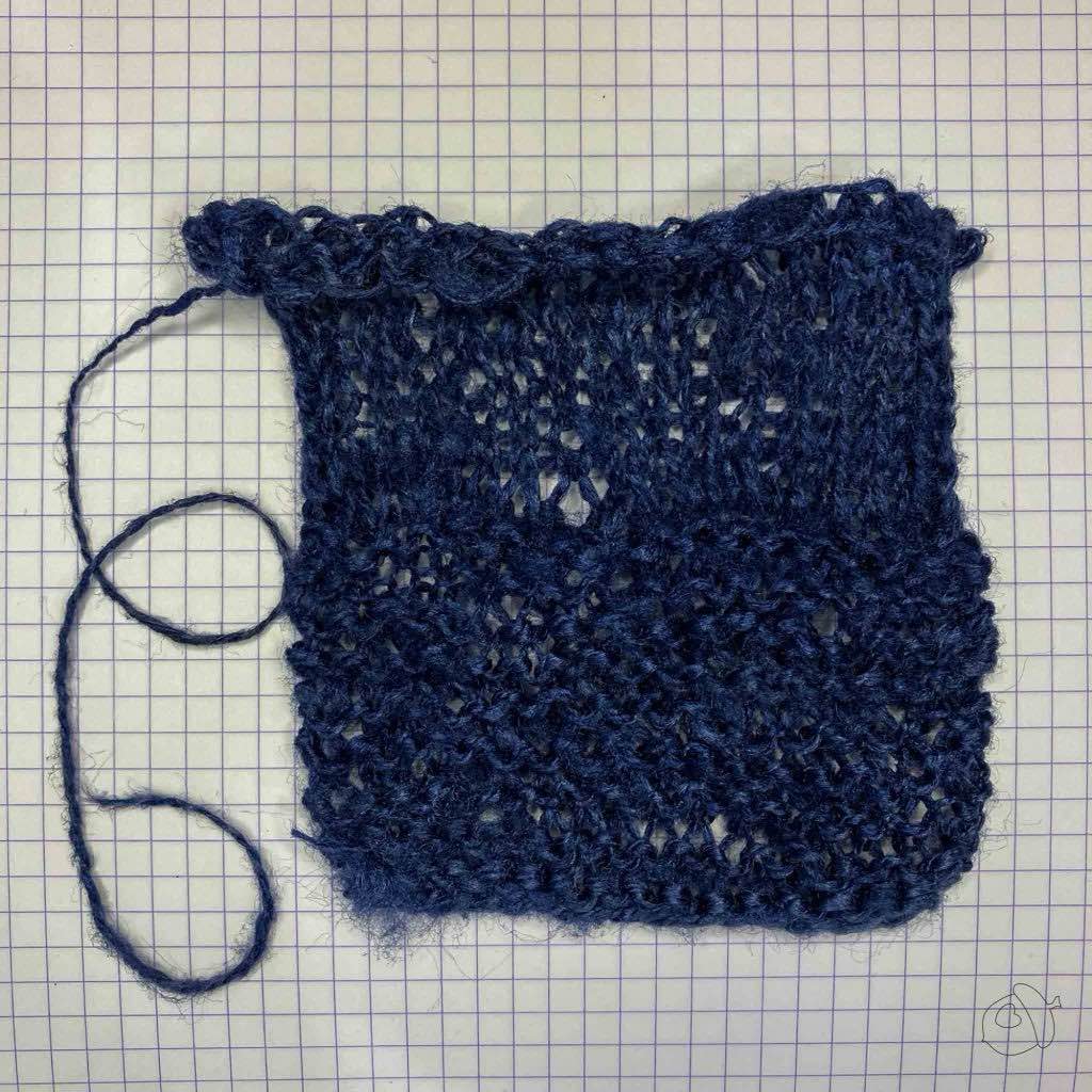 Unblocked dark navy knit swatch of ColourMart fingering weight crepe style silk bakketta